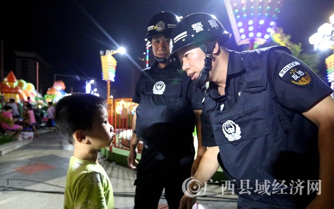 圖7:9月15日夜,在廣西柳州市融安縣長(zhǎng)安廣場(chǎng),執(zhí)勤民警為與家長(zhǎng)走失的一名小朋友提供幫助。(譚凱興 攝)_副本
