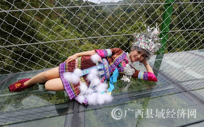 圖2:9月25日,一名苗族姑娘在廣西柳州市融水苗族自治縣融水鎮(zhèn)新國村古選屯雙龍溝體驗(yàn)懸索玻璃橋。(譚凱興 攝)_副本.j
